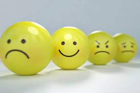 Three yellow spheres with different facial expressions on, sad, happy and angry.