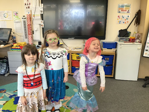 Three Nursery children in dress-up costumes.